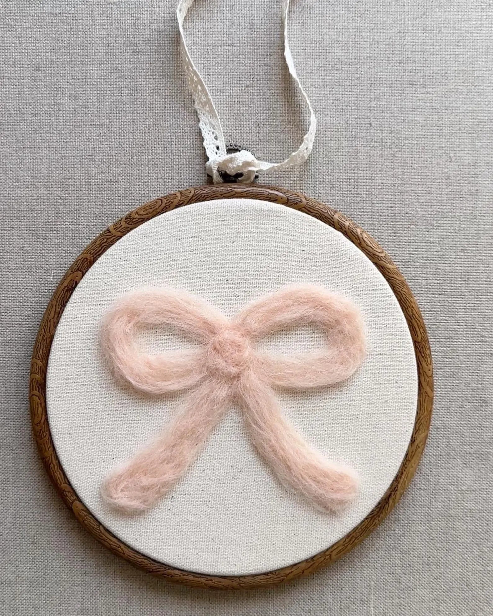 Decorative hoop with a pink bow on a neutral background