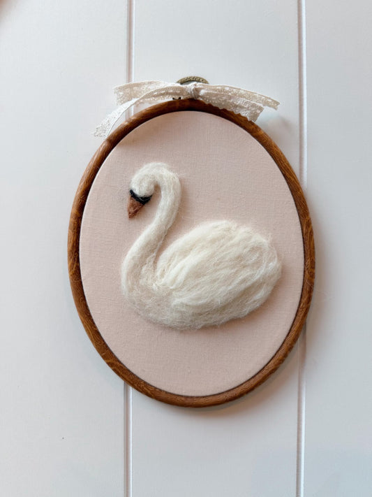 Decorative hoop with a white felt swan on a Pink background